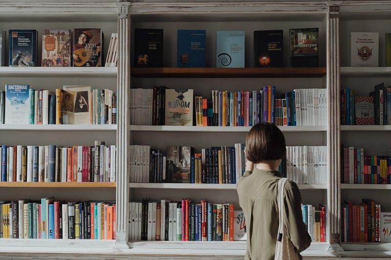 A person looking a philosophy book shelf - to illustrate how To Benefit From Negative Emotions