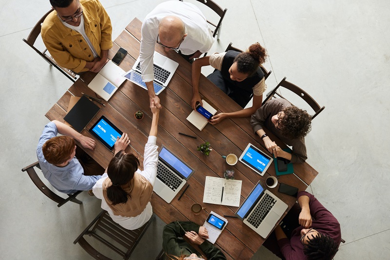 An aerial shot of a team of software developers working on together with their laptops.