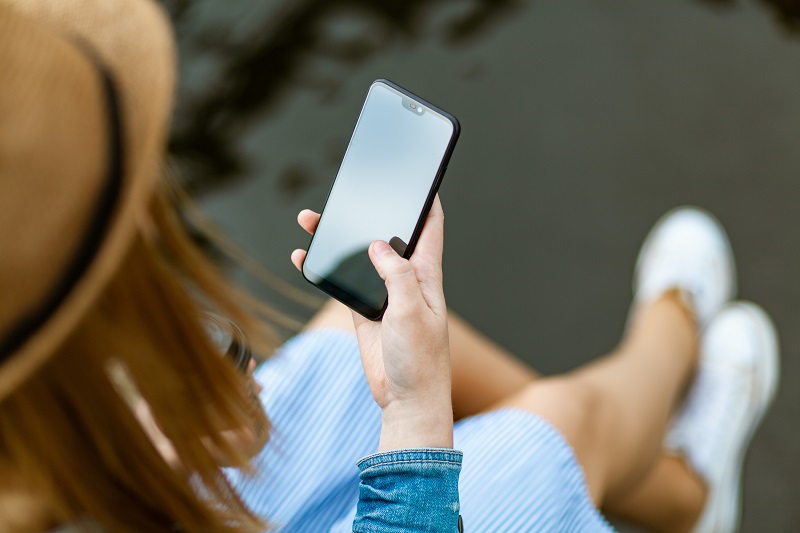 3 Exploits Of The Anchoring Effect - An image showing a woman using her smartphone