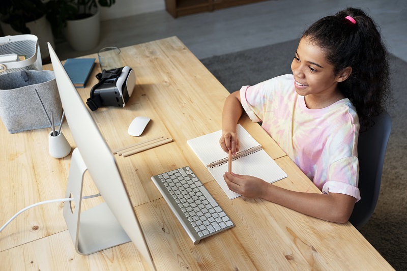 Is Higher Education A Scam? - A child learning online sitting in front of a computer.