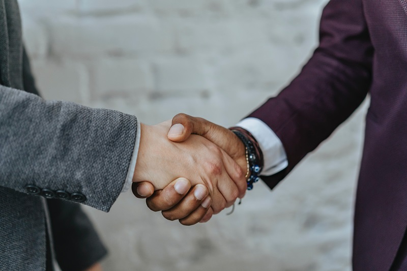 3 Exploits Of The Anchoring Effect - An image showing two people shaking hands.