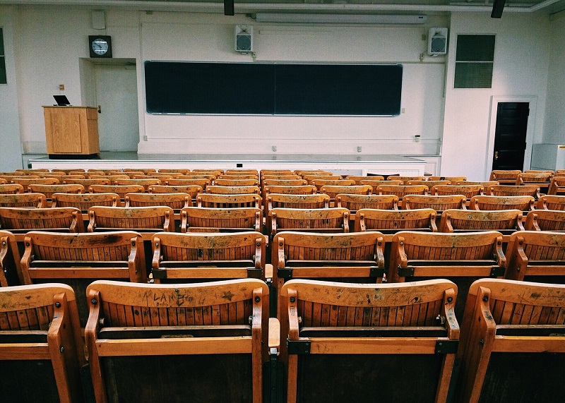 Is Higher Education A Scam? - An image showing an empty lecture hall with a huge black board and foldable seats.