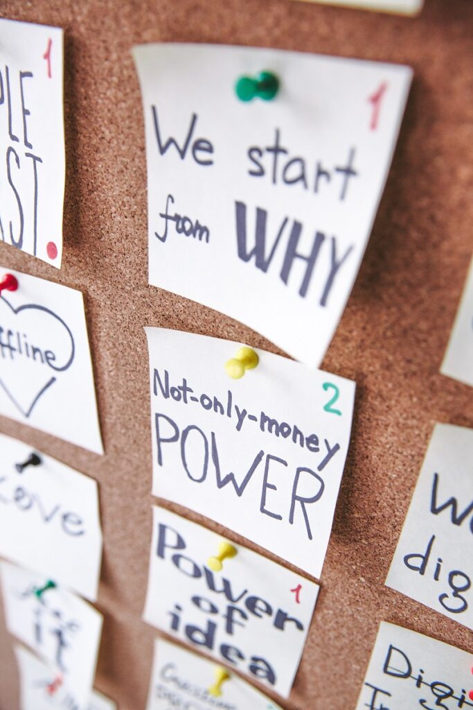 Why Do We Keep Missing Goals? - A cork board with a lot of goal related slogans pinned to it.