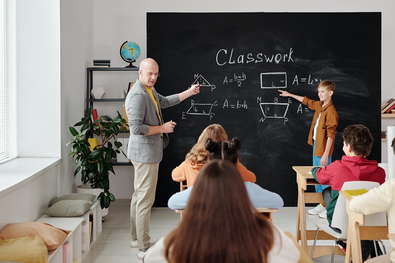 A teacher in a classroom that apparently doesn't seem to have much technology dependency