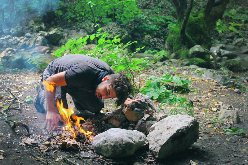 A survivor trying to light a fire without technology dependency