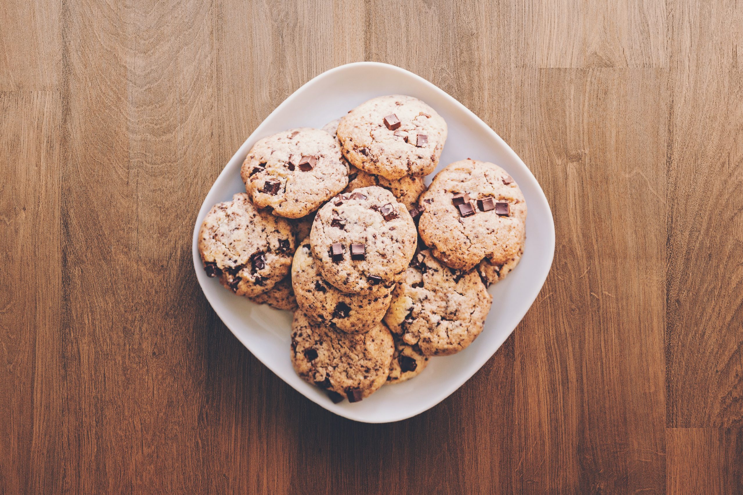 A bowl of delicious looking cookies on a brown table