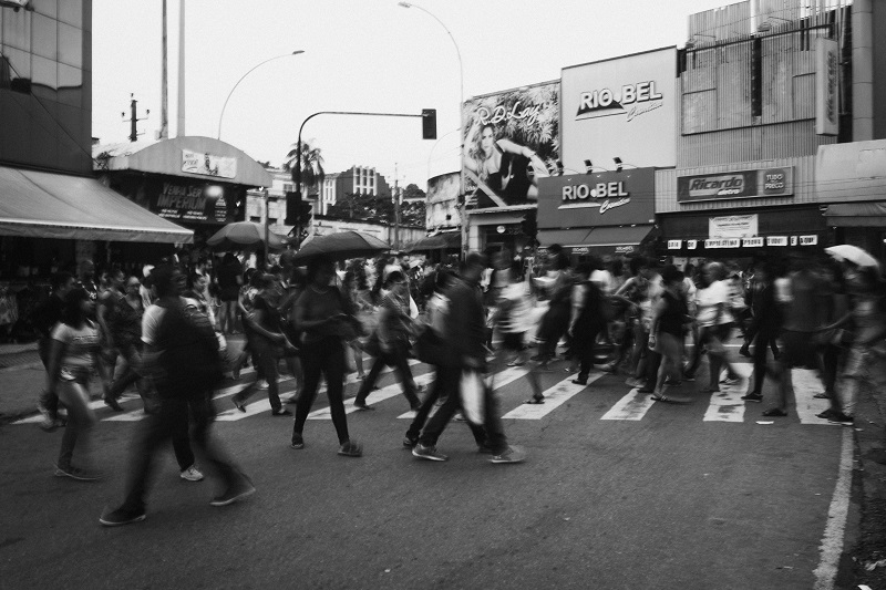 An image of a buzzling crowd crossing a road in the rain - to illustrate why you love negativity