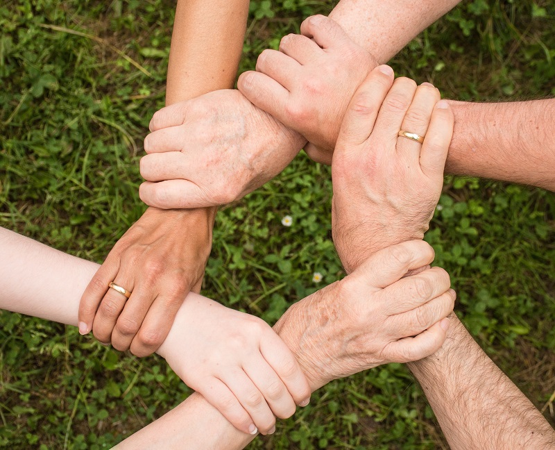 An image illustrating hands held as a community as a metapor to open source software community