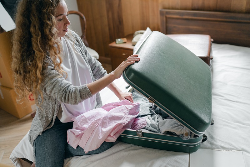 An image of a woman packing for a vacation - to illustrate why you unplug your usb